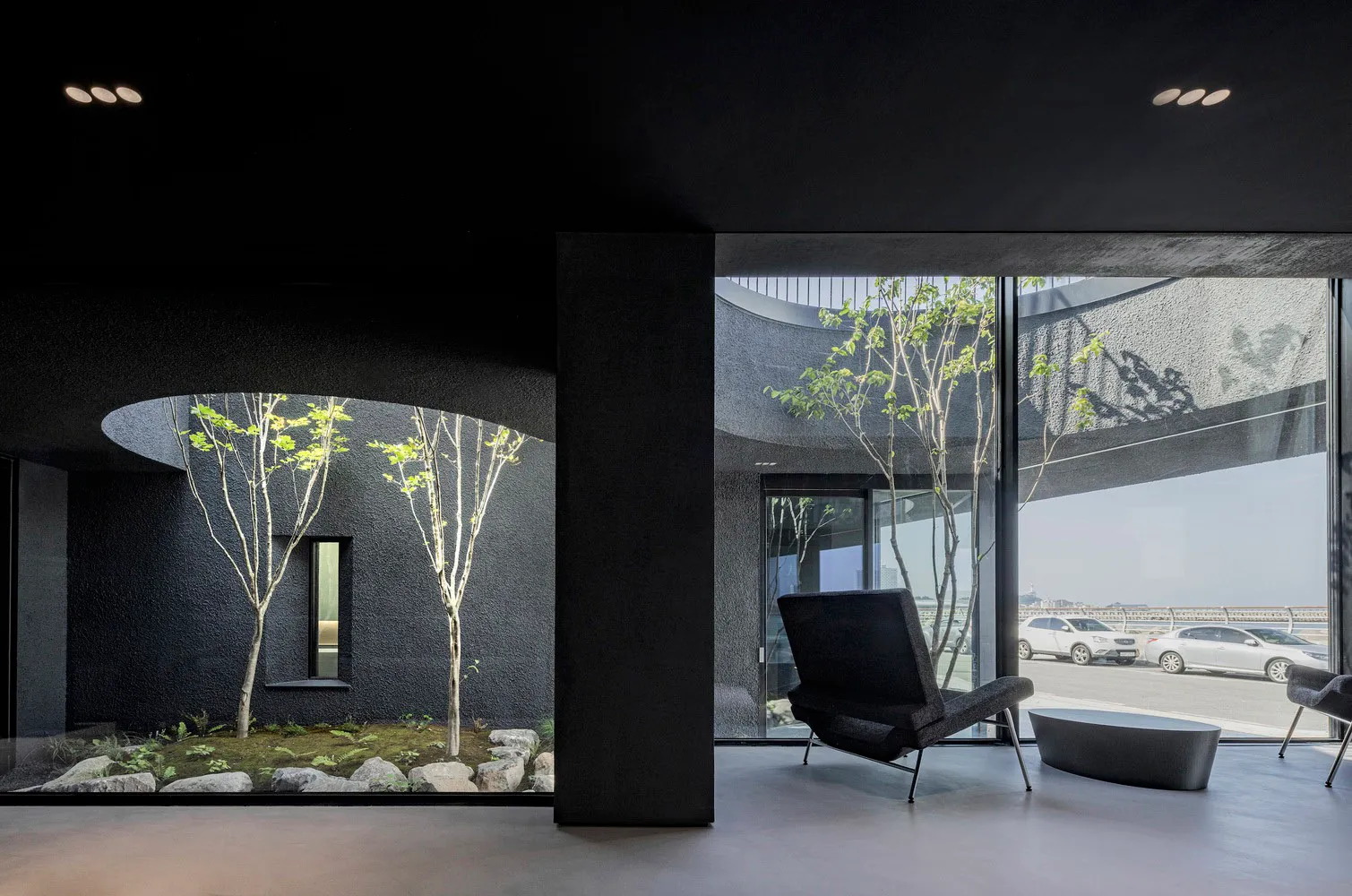 Modern lobby with glass and concrete walls, featuring a minimalist design with clean lines and natural lighting.