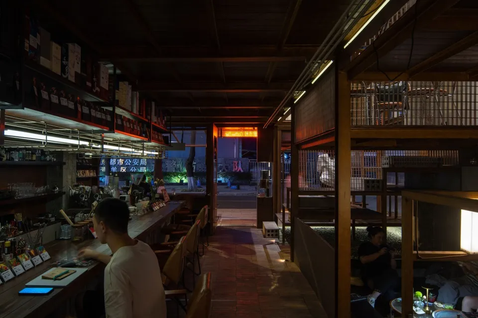 A dimly lit restaurant bar with wooden decor and seating.