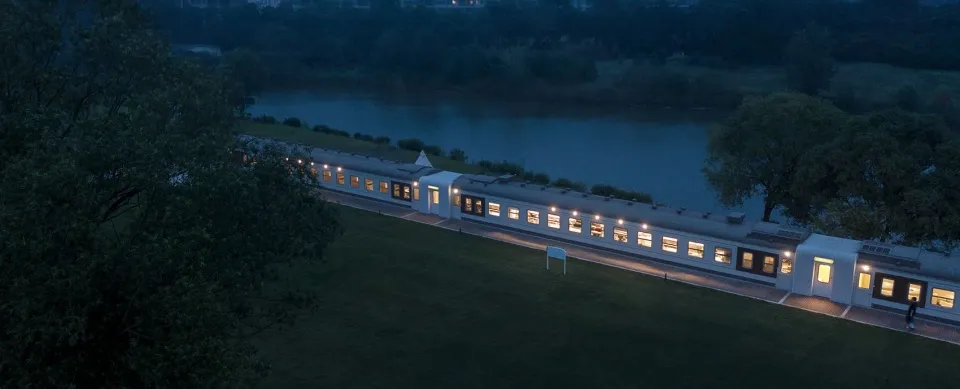 A modern train with a sleek design and illuminated windows.