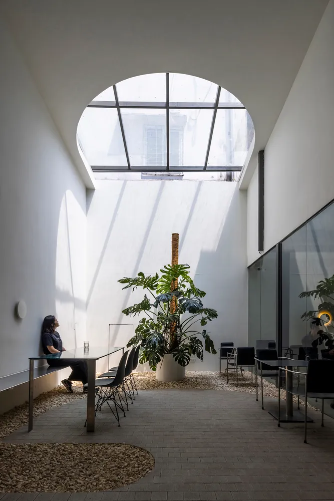 A modern office lounge featuring concrete, glass, and wood materials.