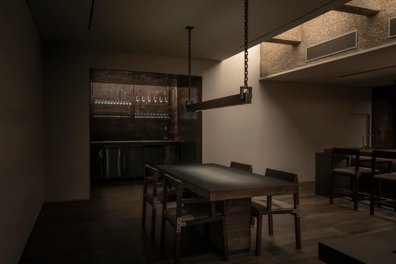 工業風餐廳內部，餐區擺放木質餐桌與金屬椅，搭配簡約裝飾與燈光
