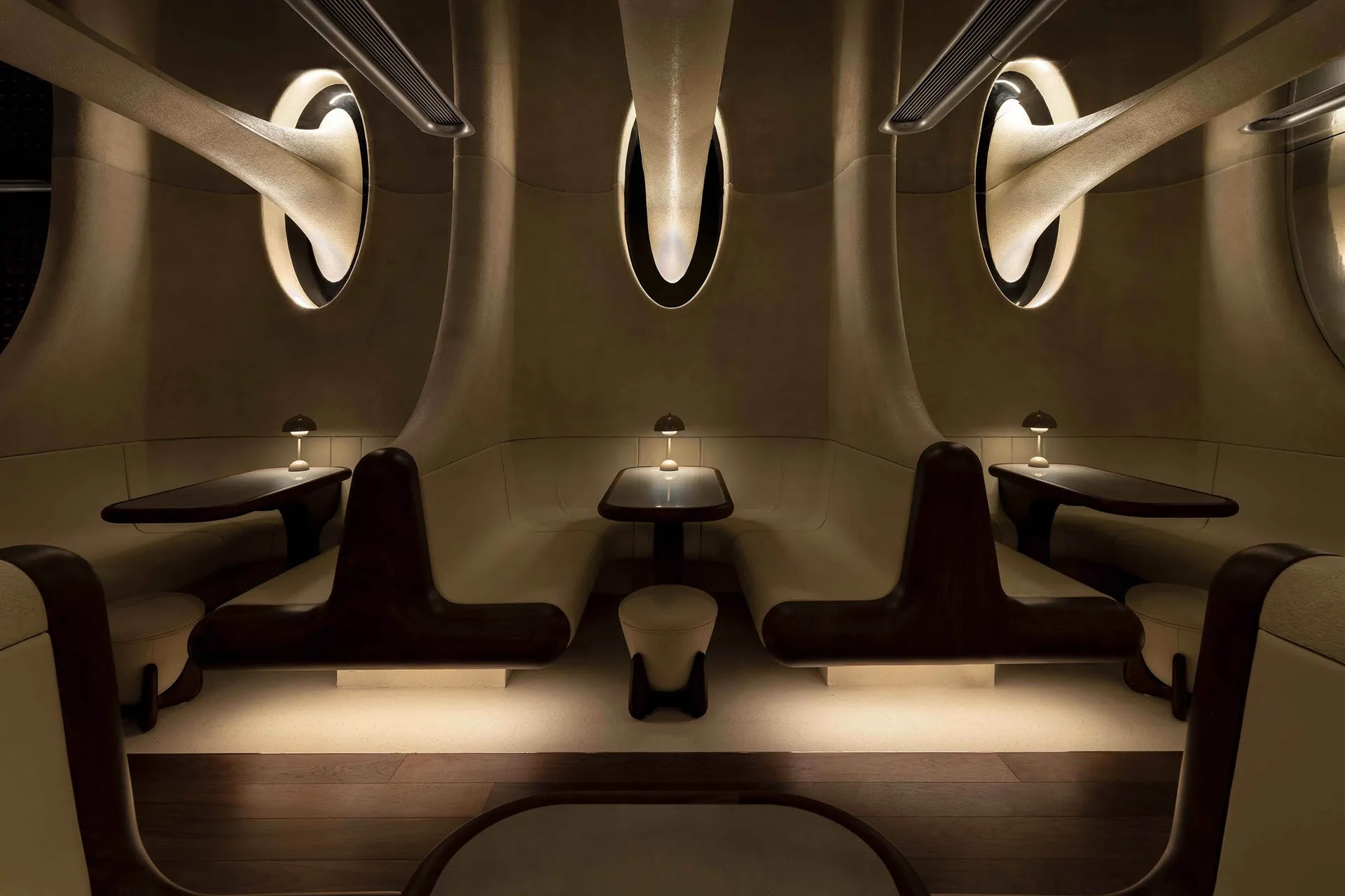 Modern restaurant with white leather booths and dark wood accents
