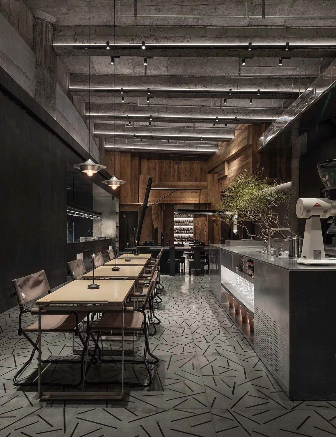 工業風餐廳室內,裸露混凝土牆面搭配木質餐桌。