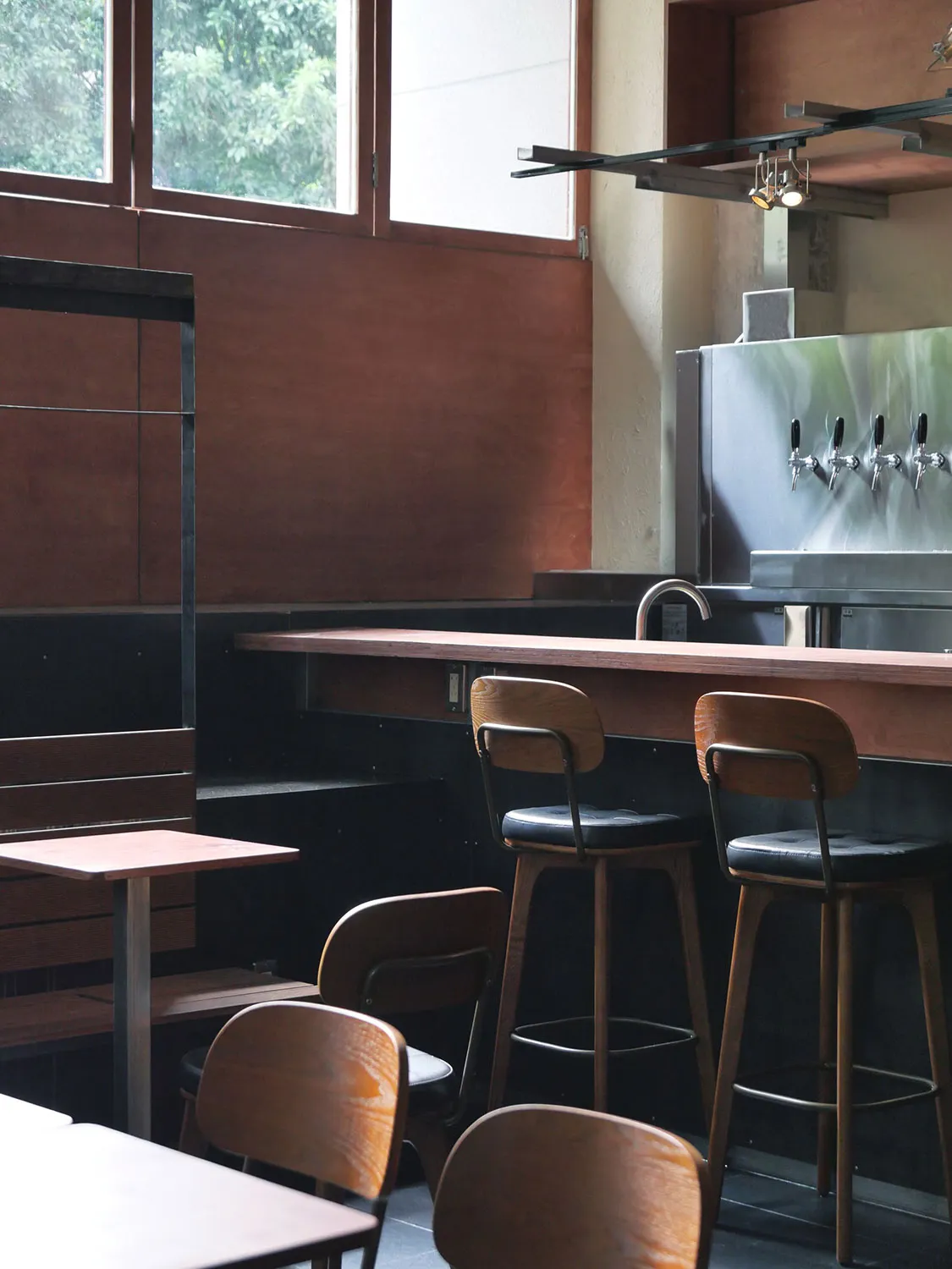 Modern restaurant bar with wooden furniture and a bar counter.