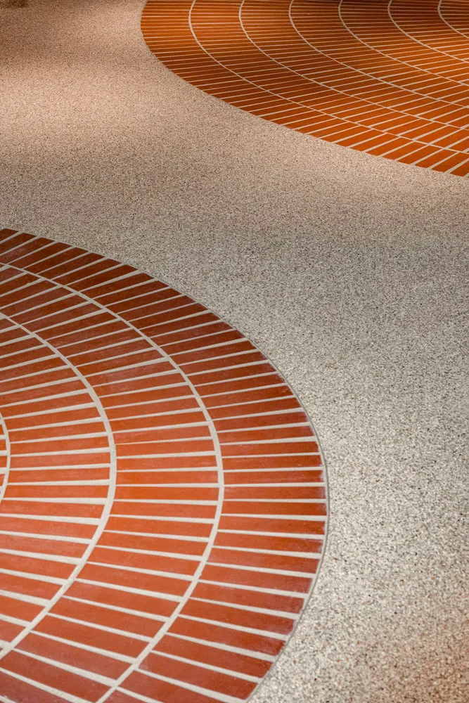Modern interior design featuring a unique pattern of red and white tiles combined with grey cement, highlighting architectura