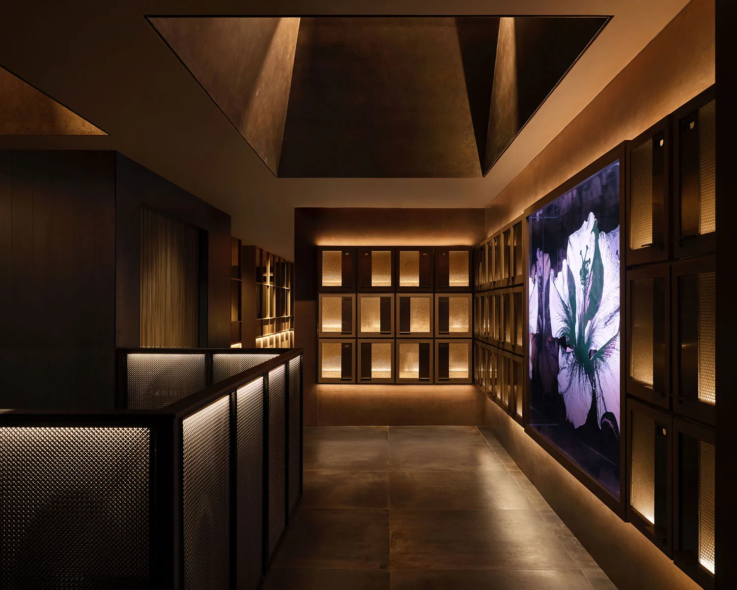 A modern business hotel suite featuring sleek metal railings, glass surfaces, and illuminated LED panels.