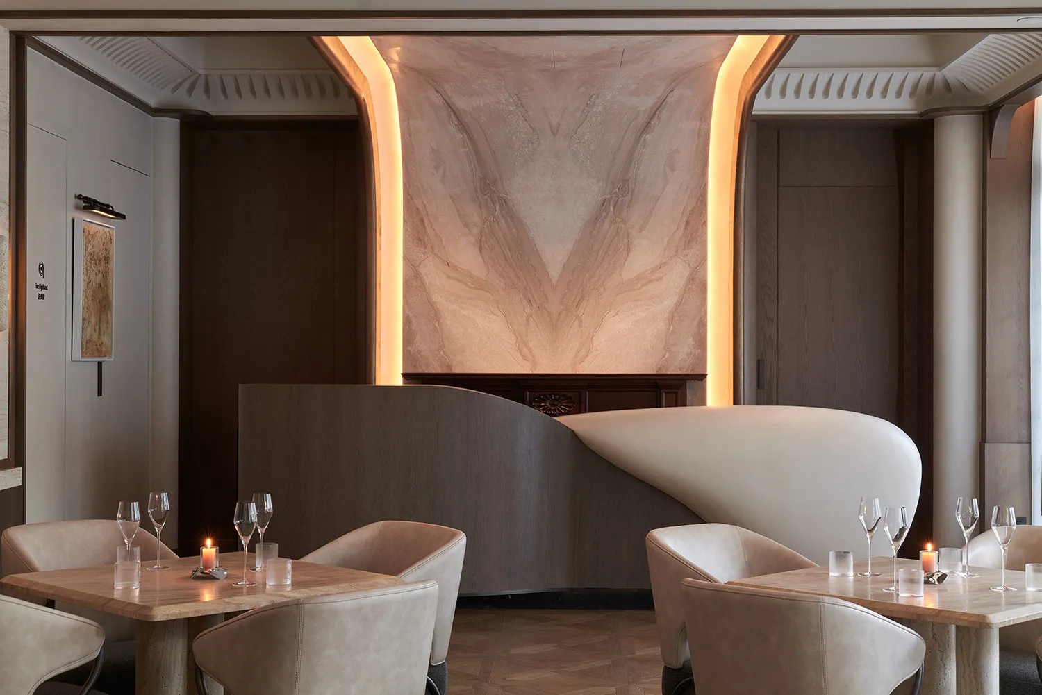 Modern restaurant interior featuring marble, wood, and leather materials.