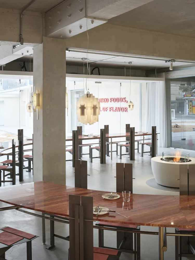 A stylish restaurant interior featuring modern concrete and wooden elements.