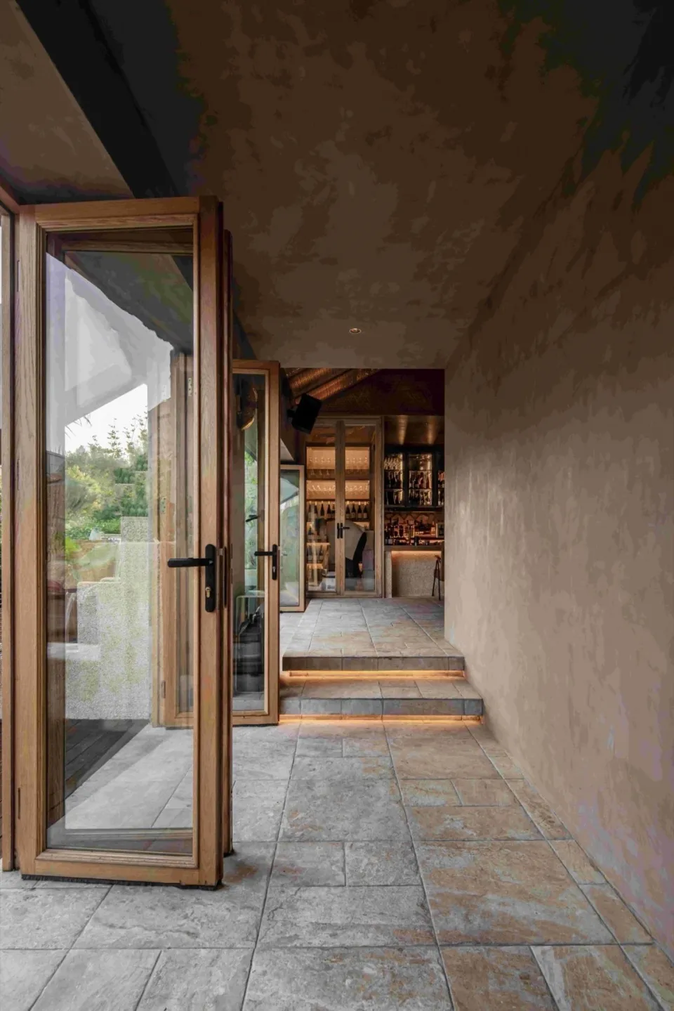 A minimalist restaurant interior with stone and wood elements, showcasing modern design and natural materials.