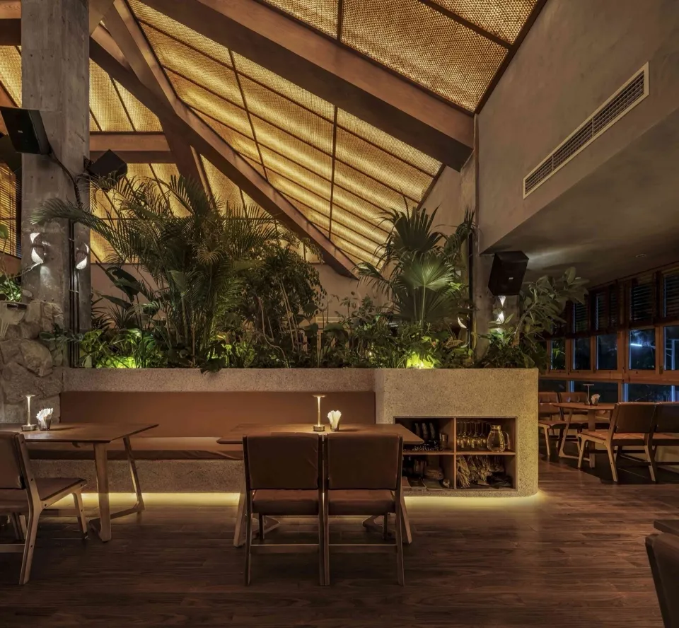 A modern restaurant interior featuring wood, concrete, and plaster materials.