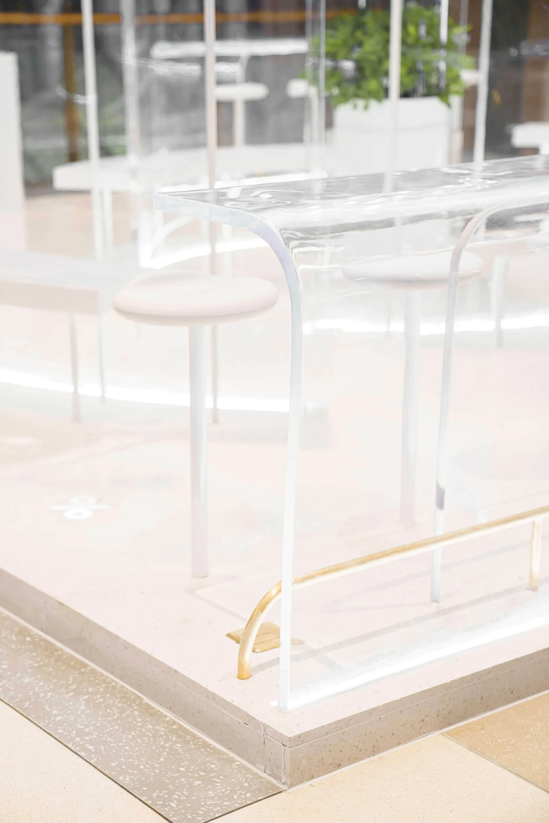 Clear acrylic restaurant counter with modern design and seating.