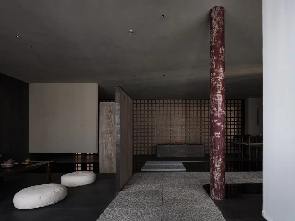 Modern minimalist living room with concrete and wooden elements.