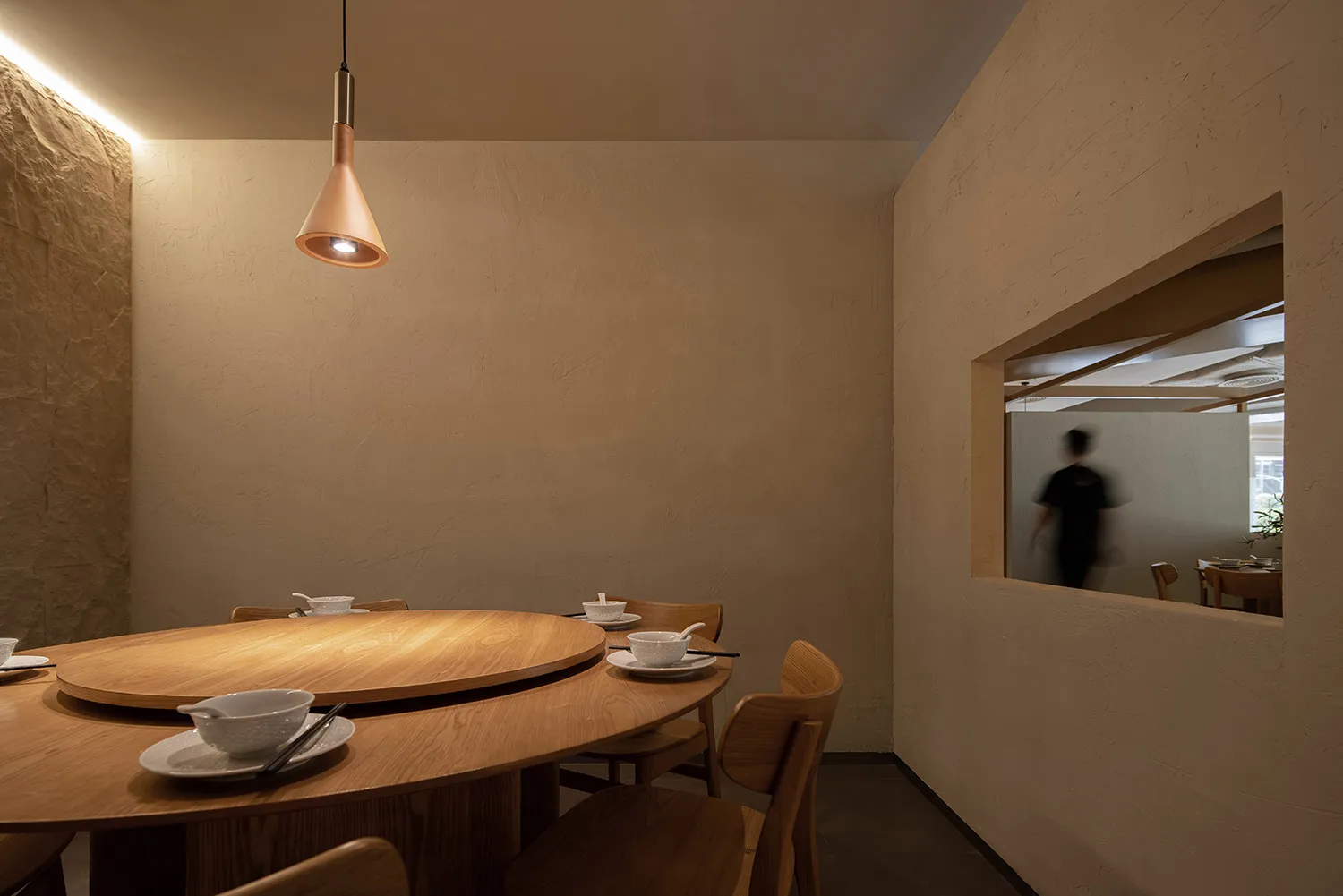 A modern restaurant interior featuring wooden furniture and a cozy atmosphere.