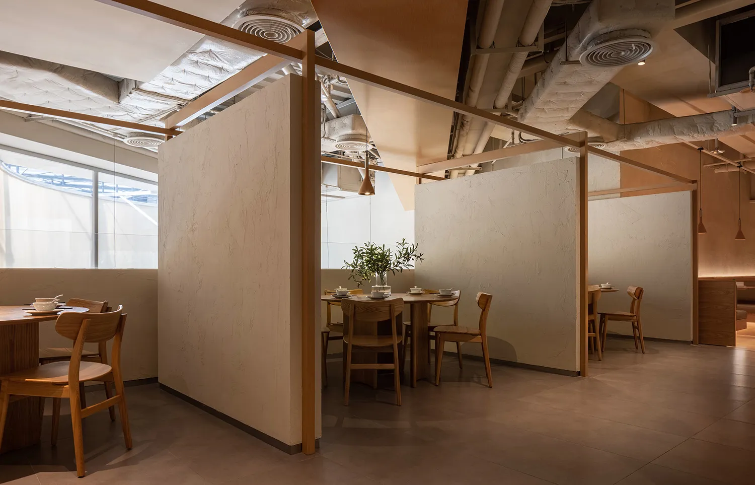 Modern restaurant with wood interior design, featuring tables and chairs.