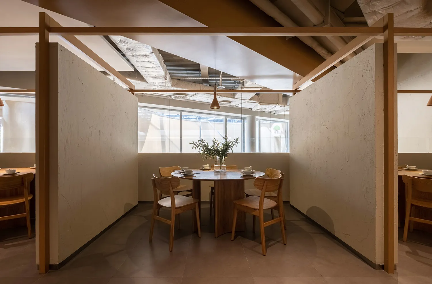 現代餐廳室內設計,搭配木質餐桌與混凝土地板,設有圓桌、座椅及簡約元素