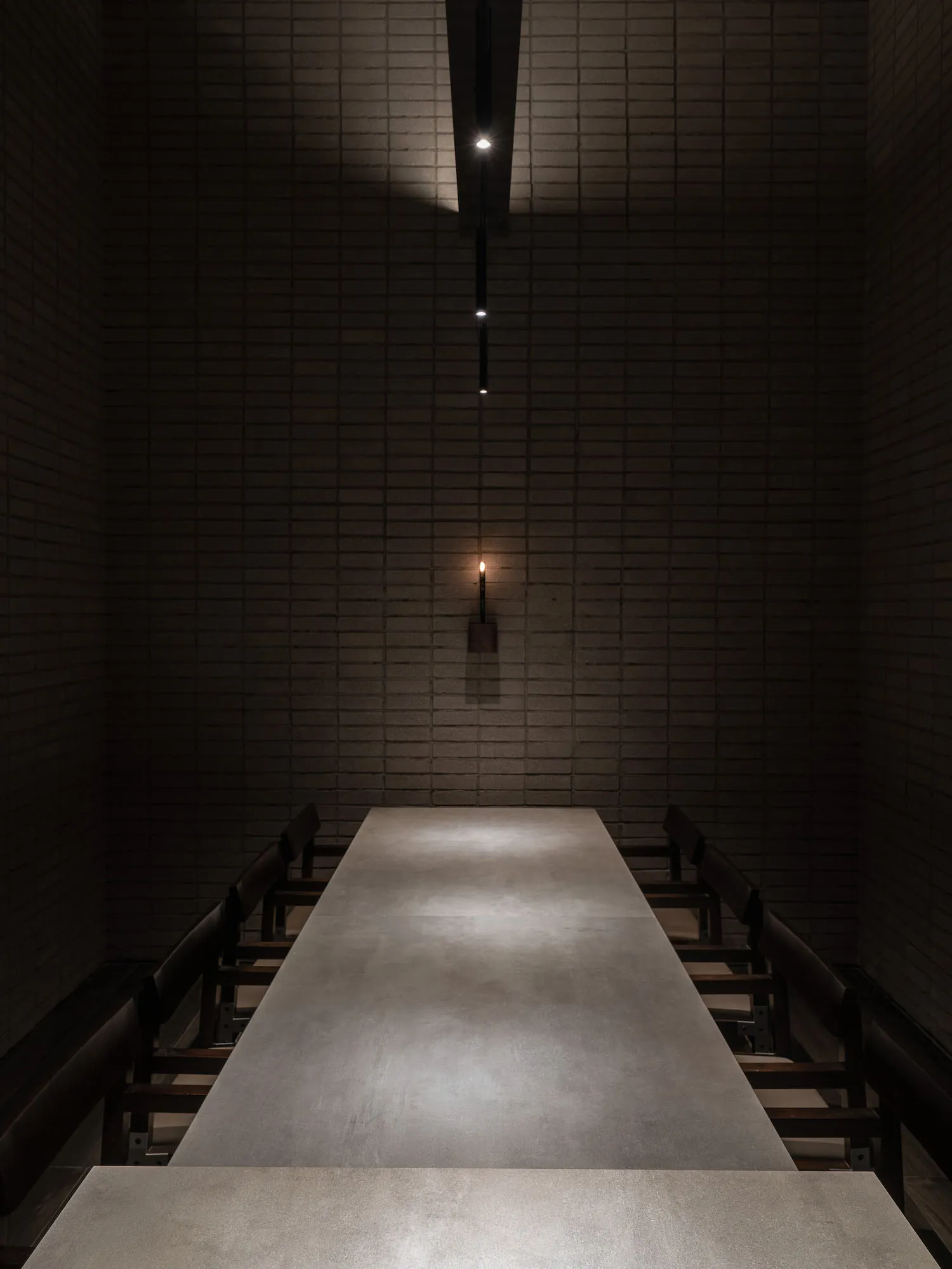A modern corridor with a concrete floor viewed from a perpendicular angle.