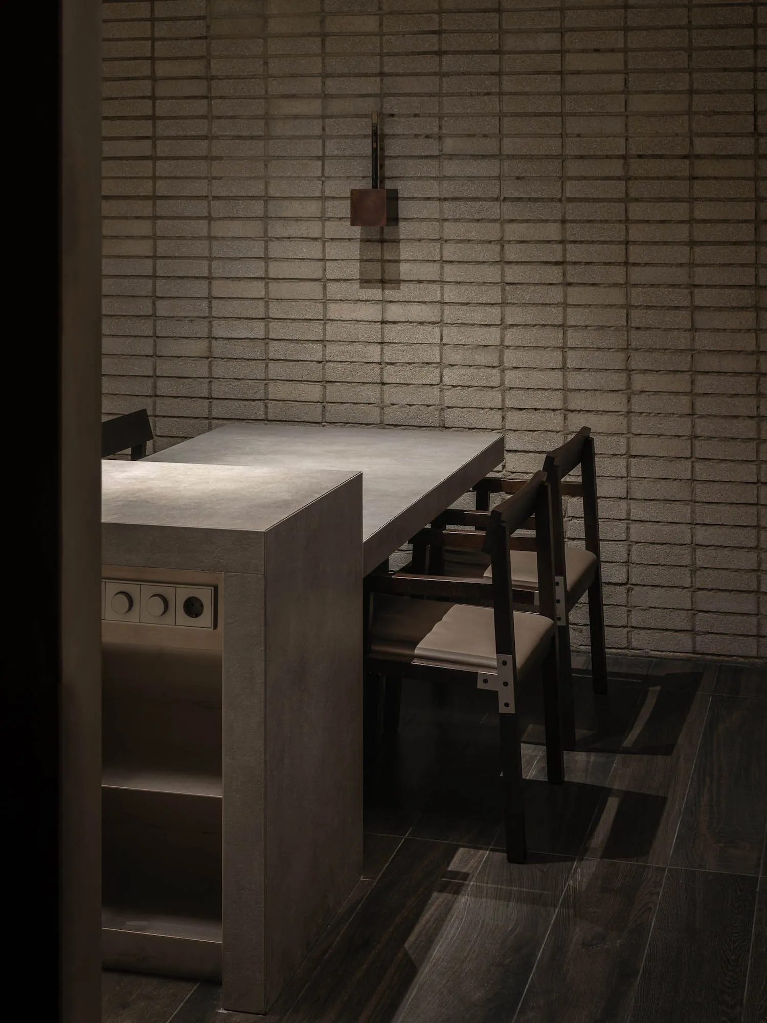 A minimalist kitchen with concrete countertops and walls.