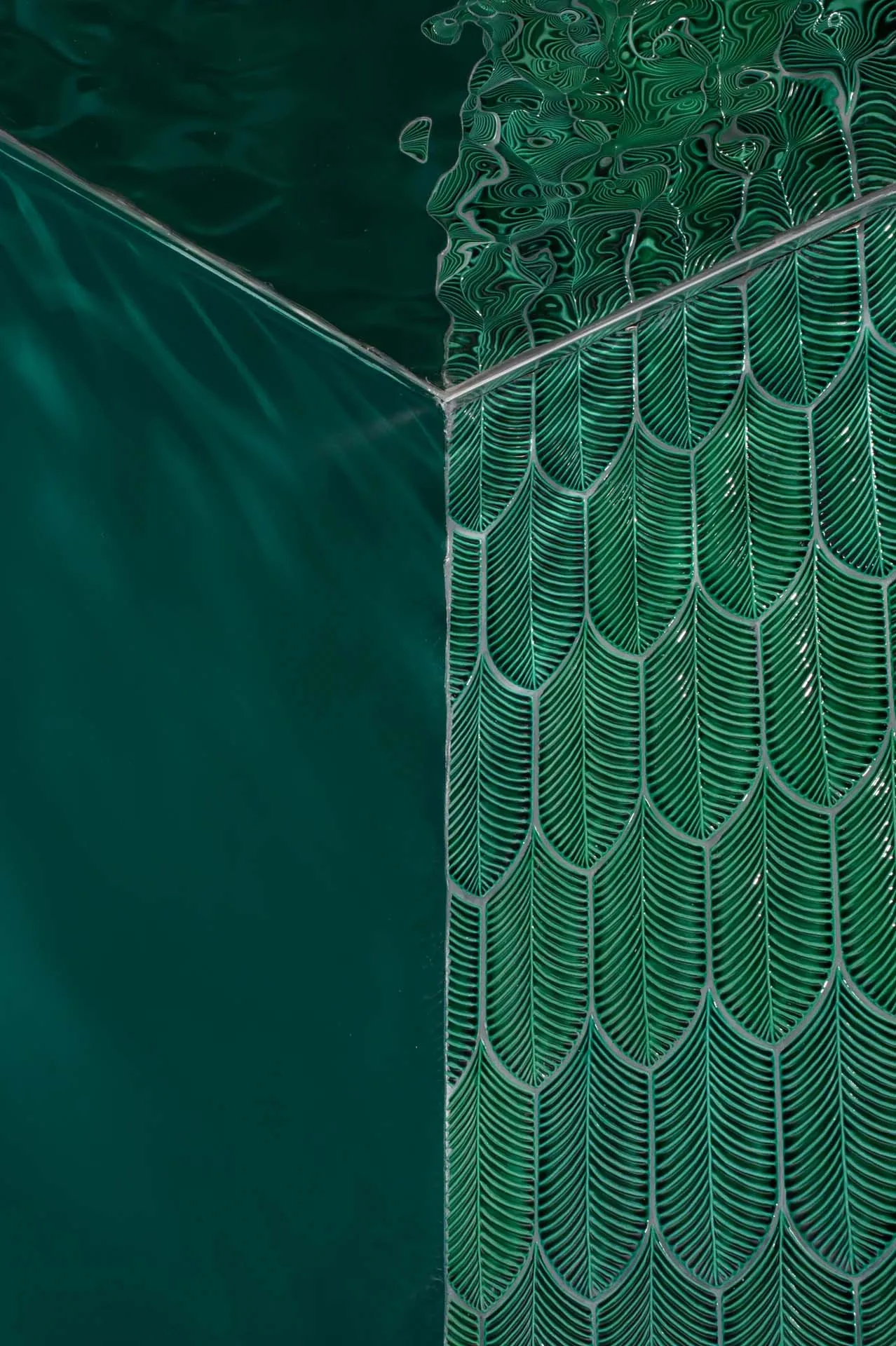 A close-up view of green scallop-patterned glass tiles