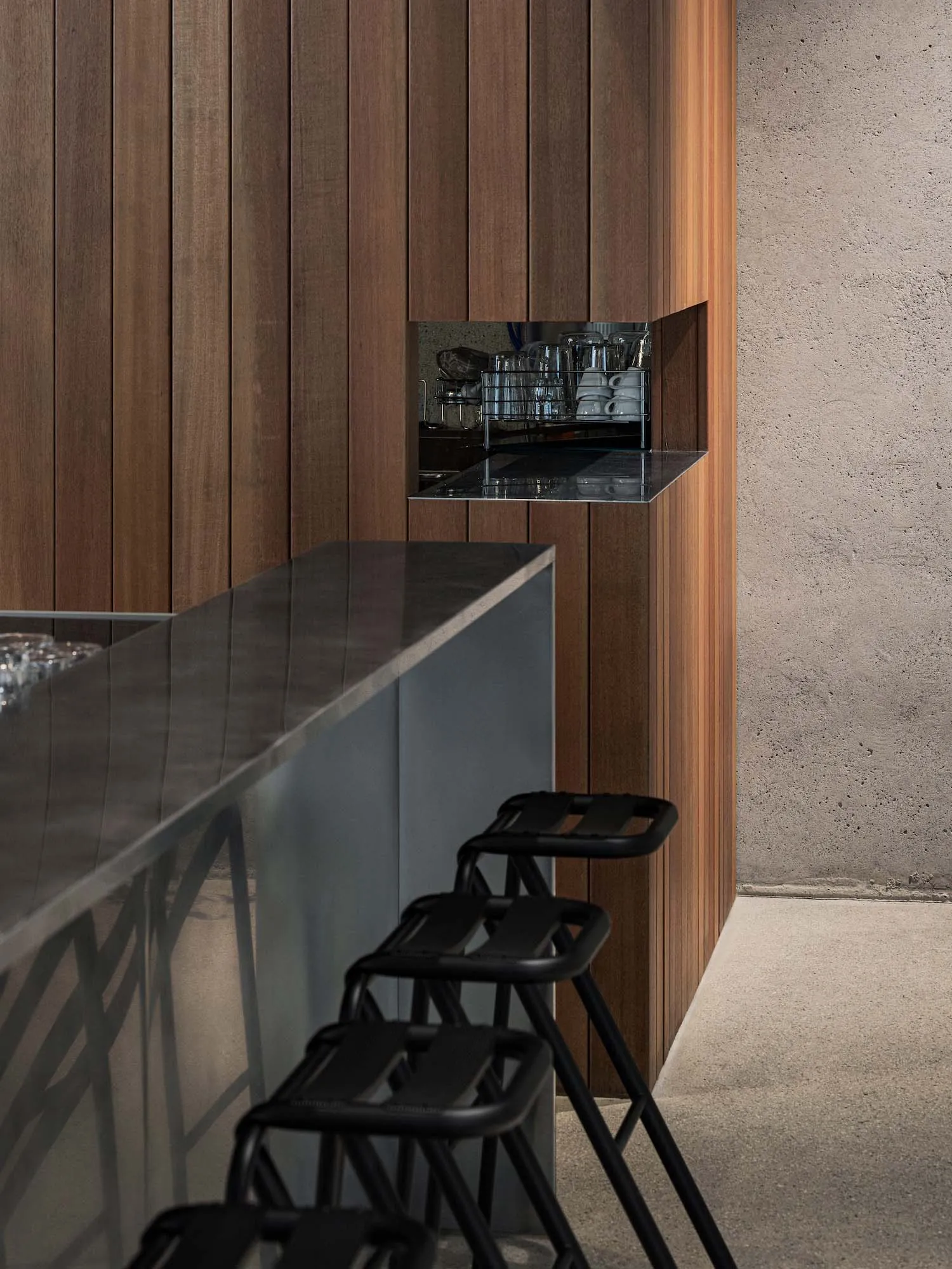 A modern bar with a metal countertop and wooden cabinets