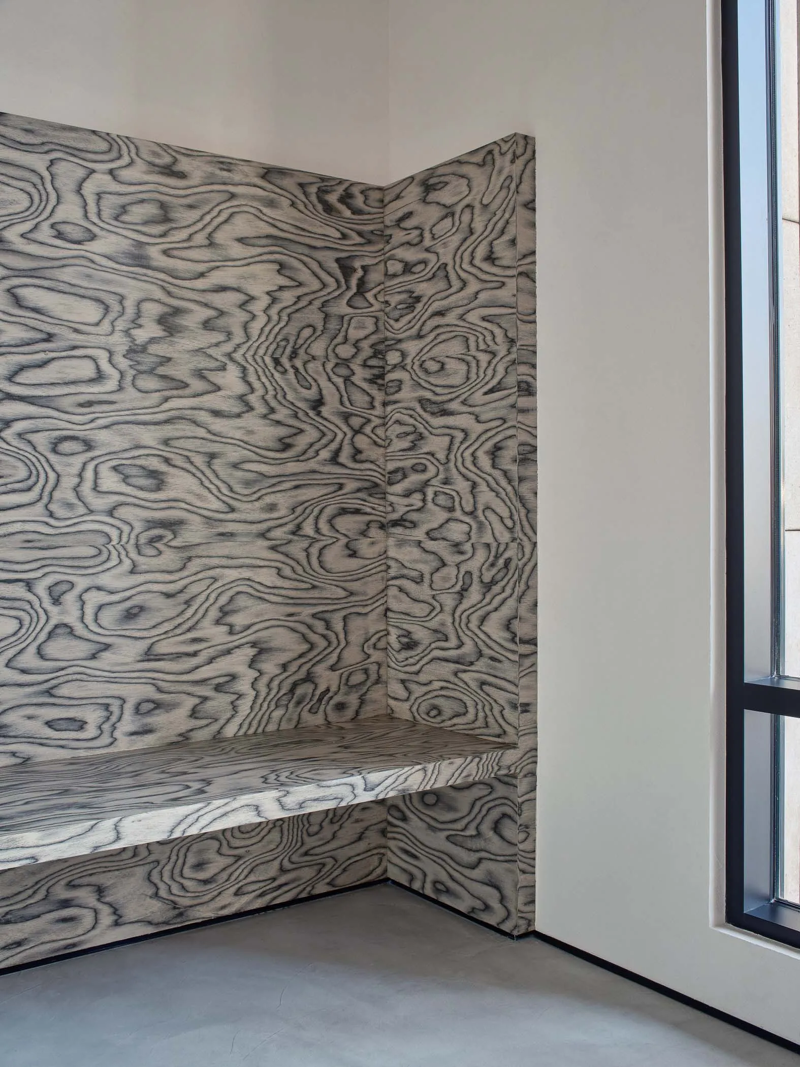 Modern industrial style interior design featuring a corner bench with a wood-patterned panel