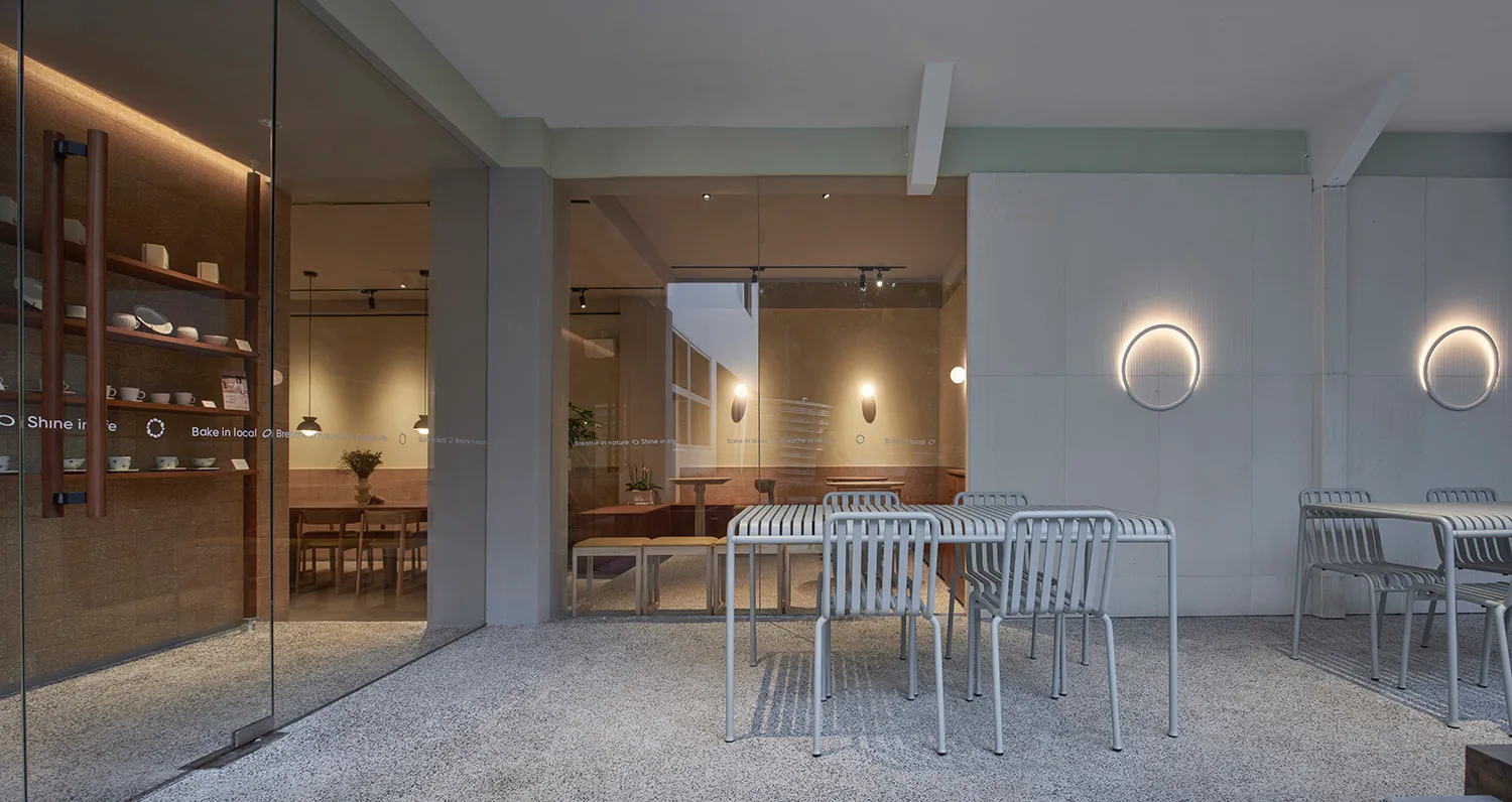 A modern restaurant interior featuring concrete tables and minimalist design elements.