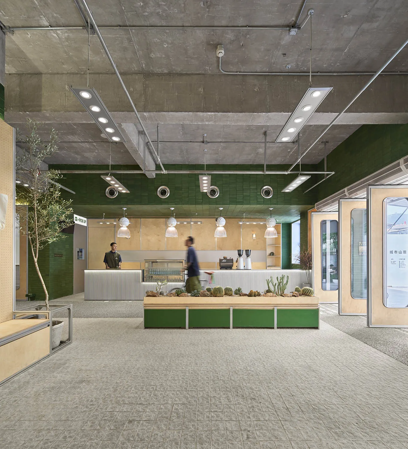 Modern minimalist cafe interior featuring concrete, wood, metal, and greenery.