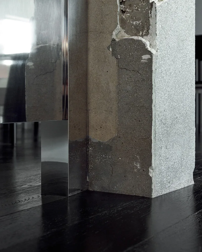 Minimalist interior design featuring a concrete column on a dark wooden floor.