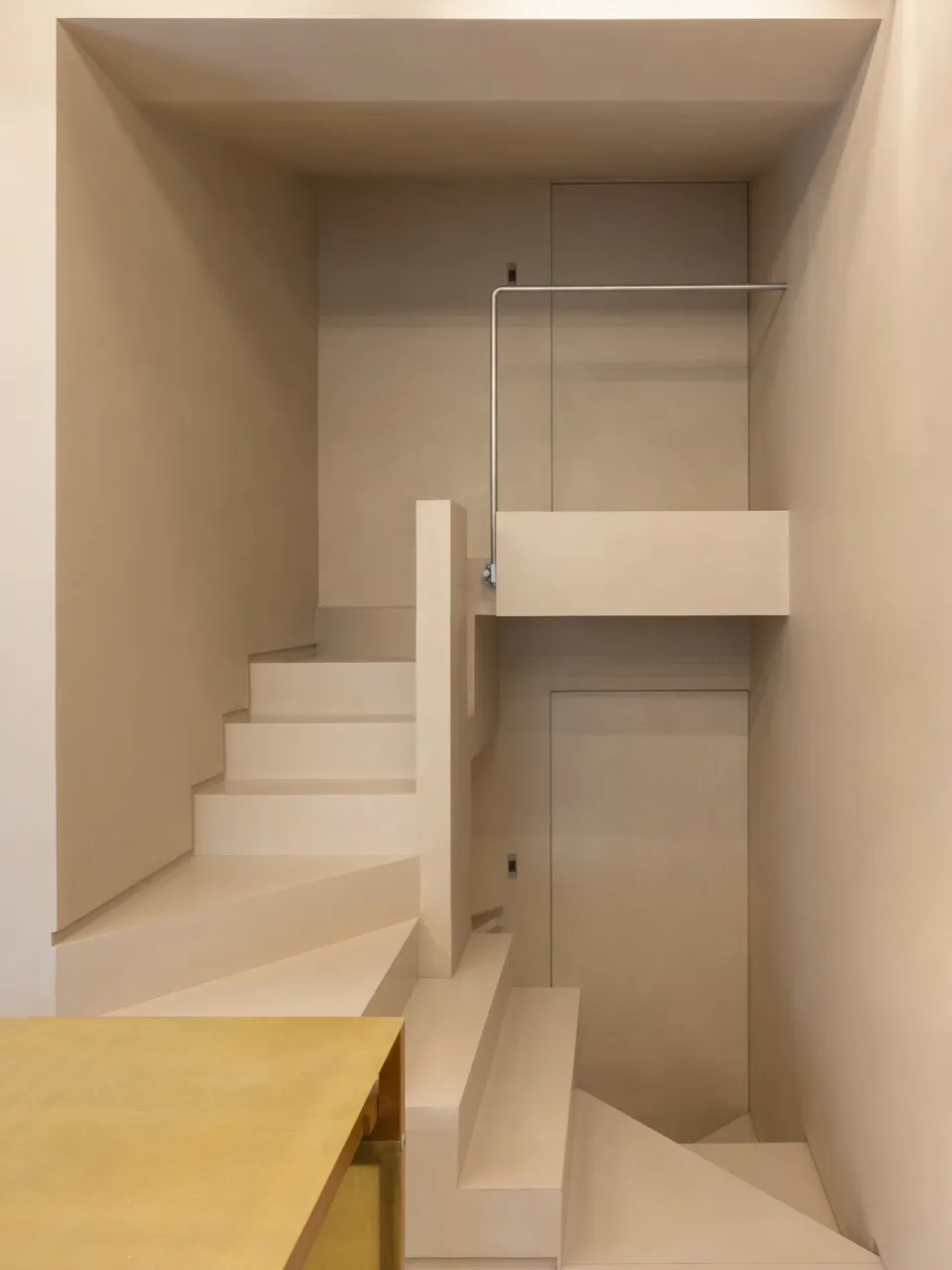 Minimalist modern interior featuring concrete stairs and metal railings.