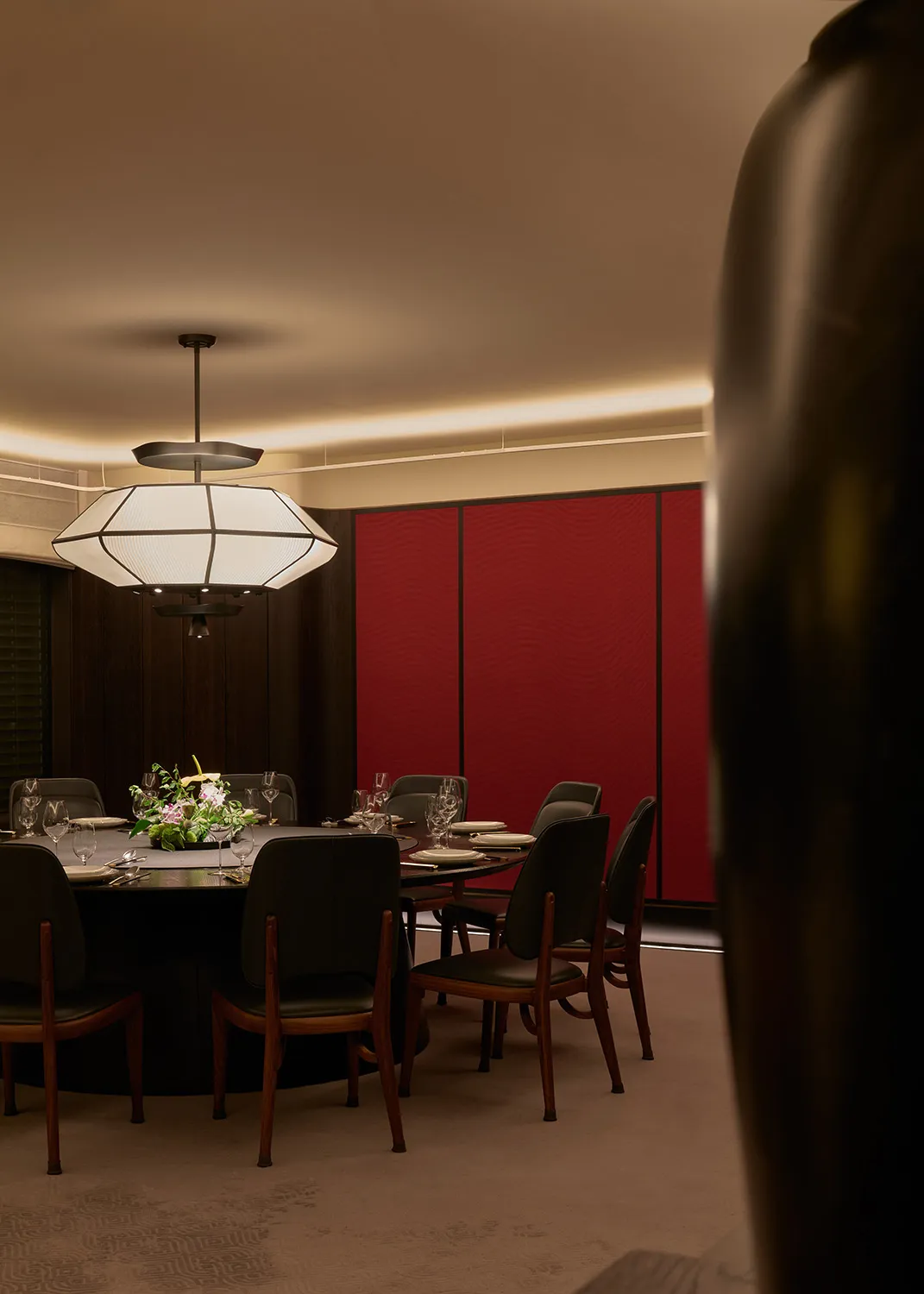 A modern dining room with wooden floors, leather upholstered chairs, and fabric tablecloth.