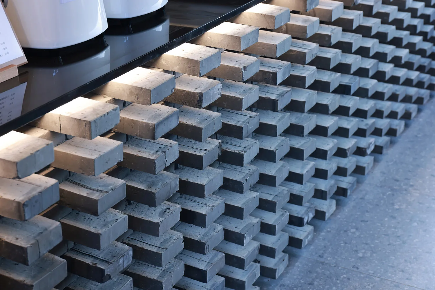 Organized arrangement of gray and brown rectangular concrete plates in an architectural setting.