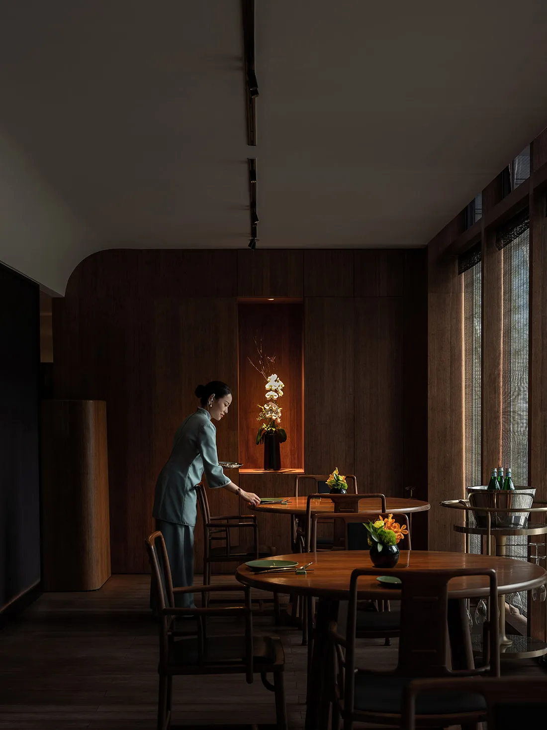 A minimalist restaurant interior with dark wood furniture and a warm, inviting atmosphere.