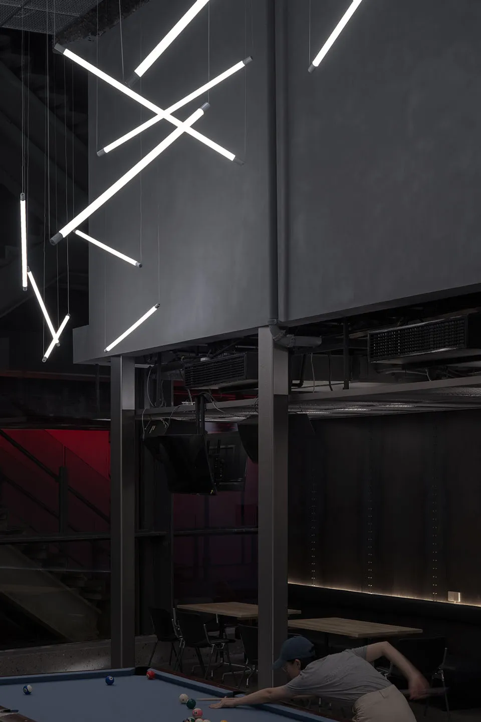 A modern bar interior featuring metal accents and concrete walls.
