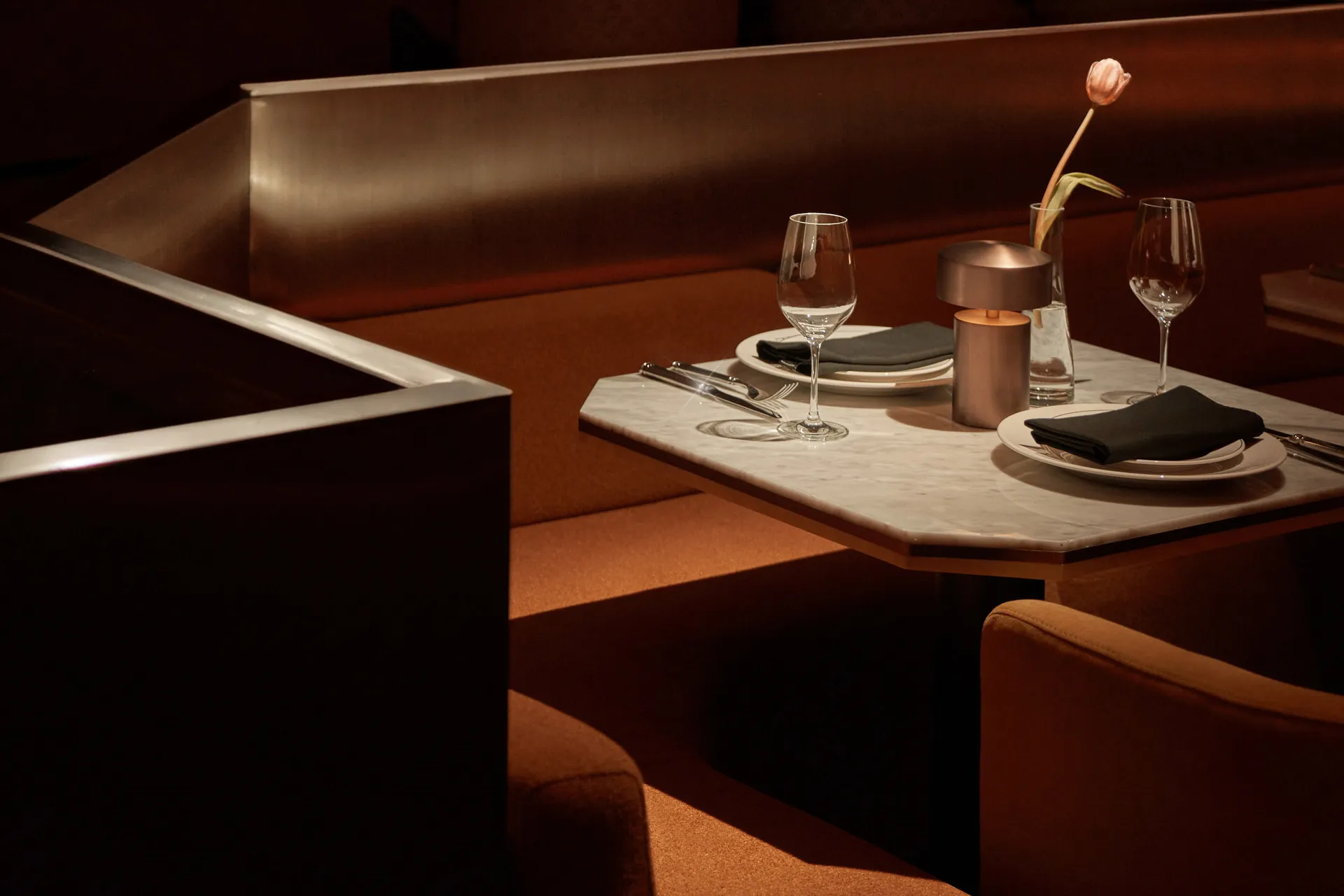 Marble table setting with dining chairs in a contemporary restaurant interior.