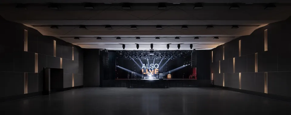 A modern concert hall with a dark interior and black lighting capitals.