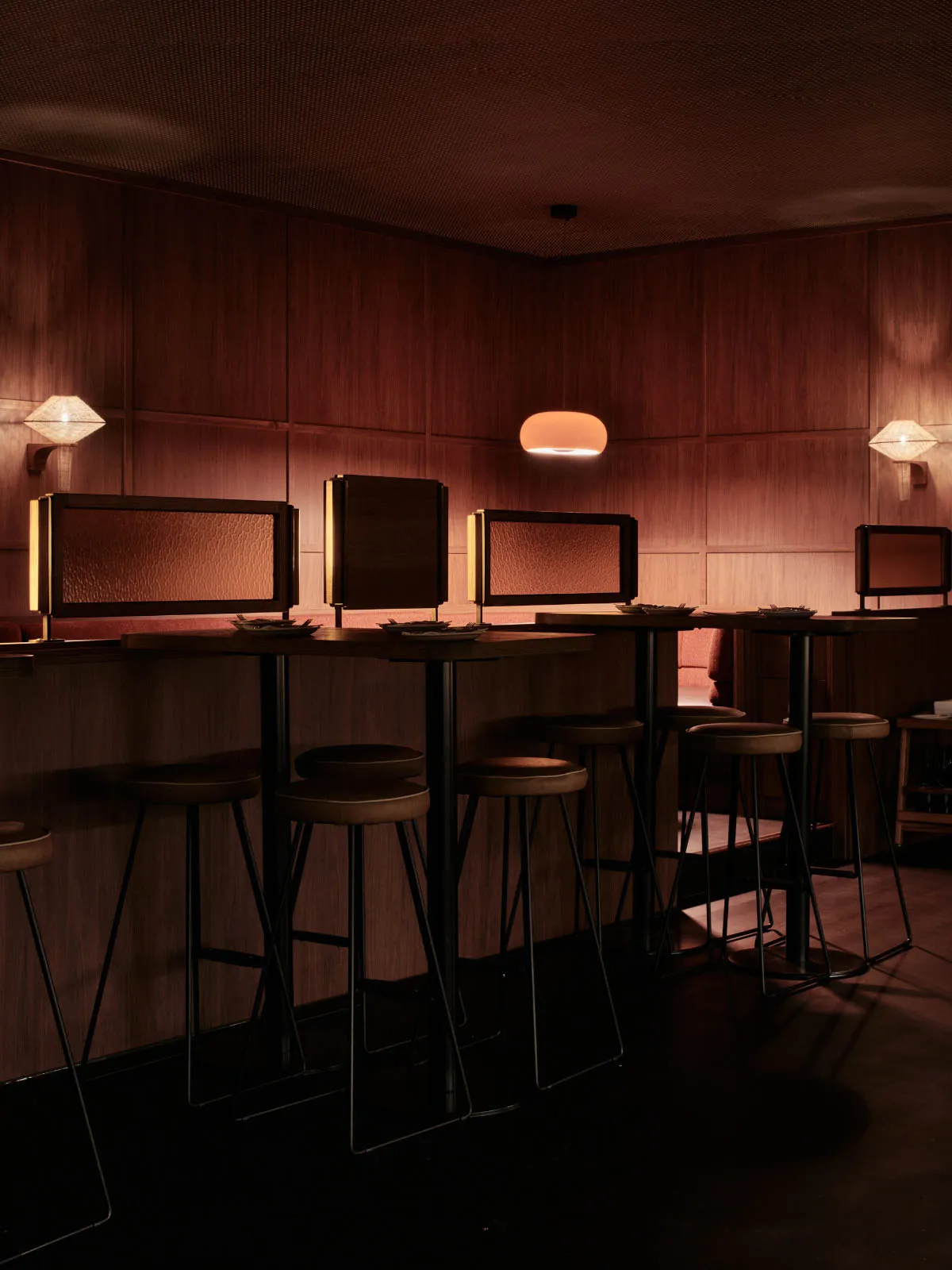 Modern restaurant bar with wooden accents and high stools.