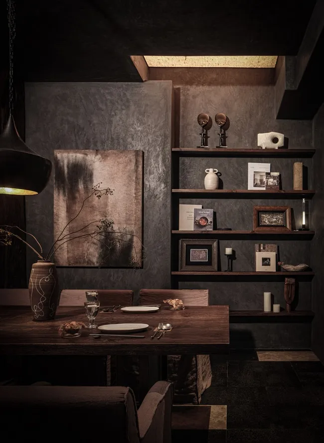 Modern industrial-style dining room with wooden table, concrete walls, and metal accents.