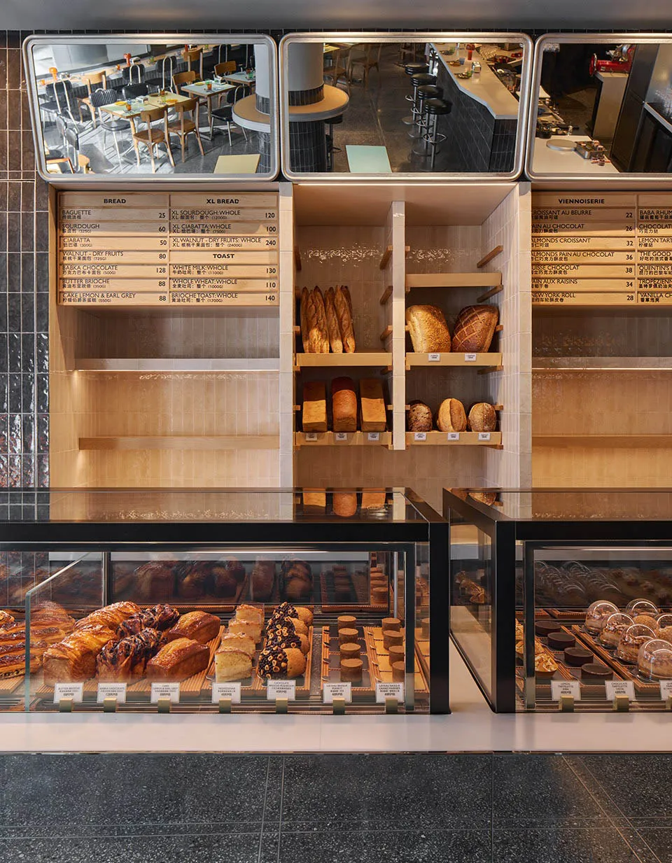 A bakery storefront with shelves displaying various breads and pastries, wood shelves, glass display cases, and ceramic tiles