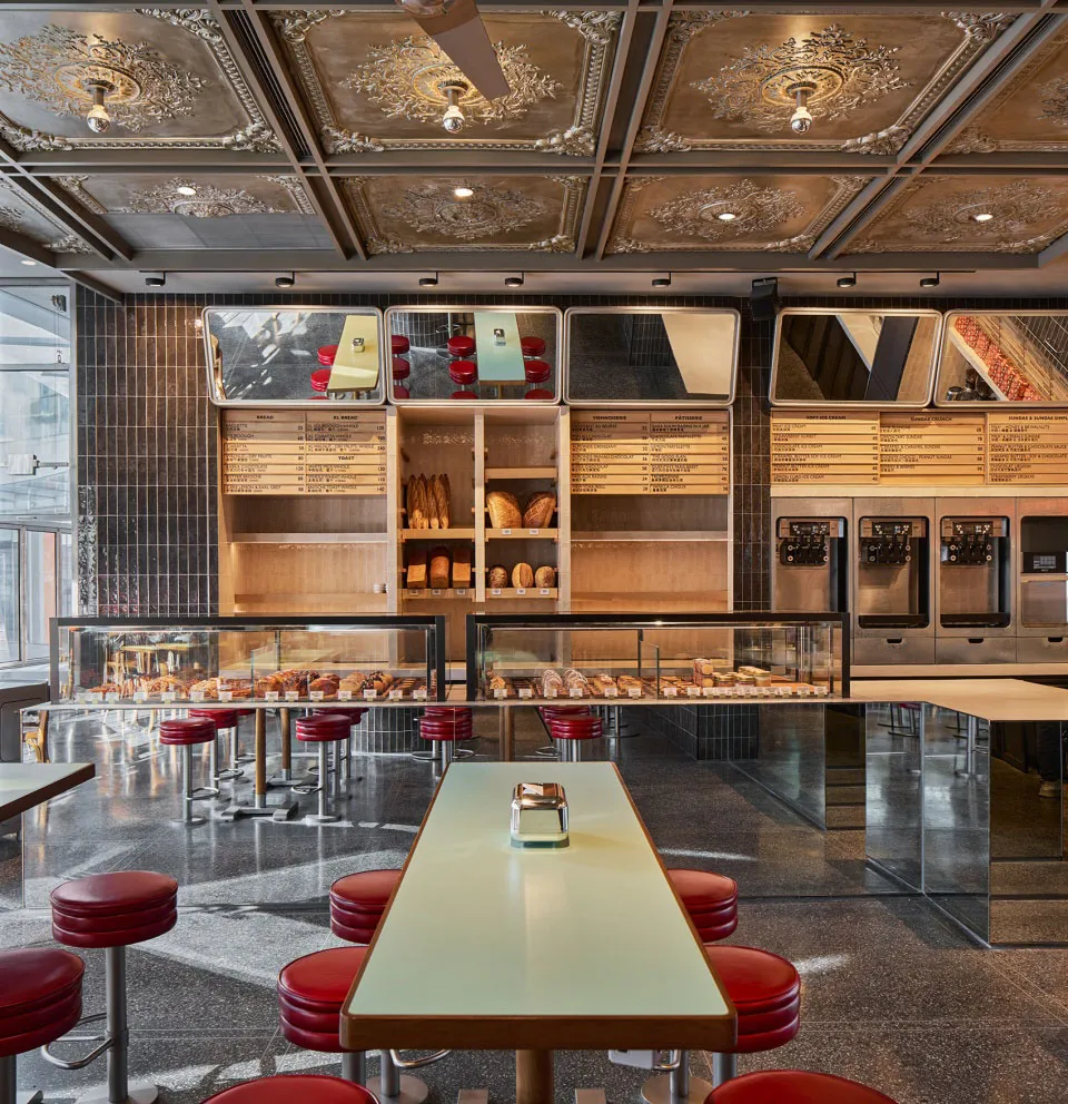 A modern French bakery with a sleek, contemporary interior featuring modern tiles, concrete, and glass.