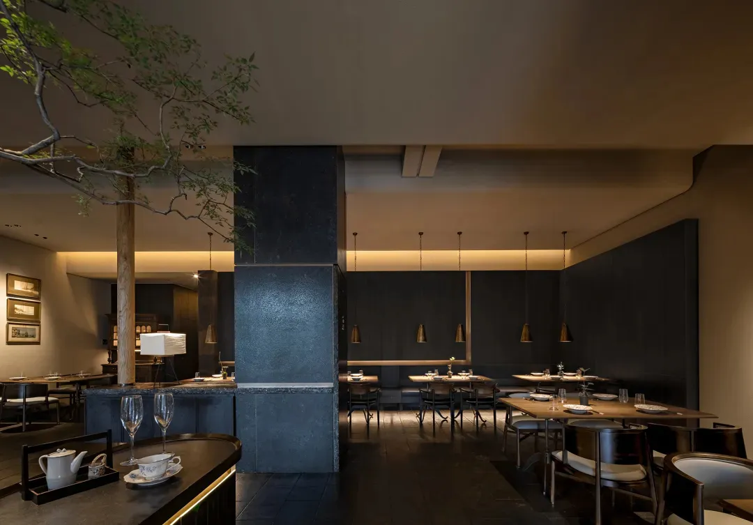 Modern restaurant interior with metallic finishes and concrete elements