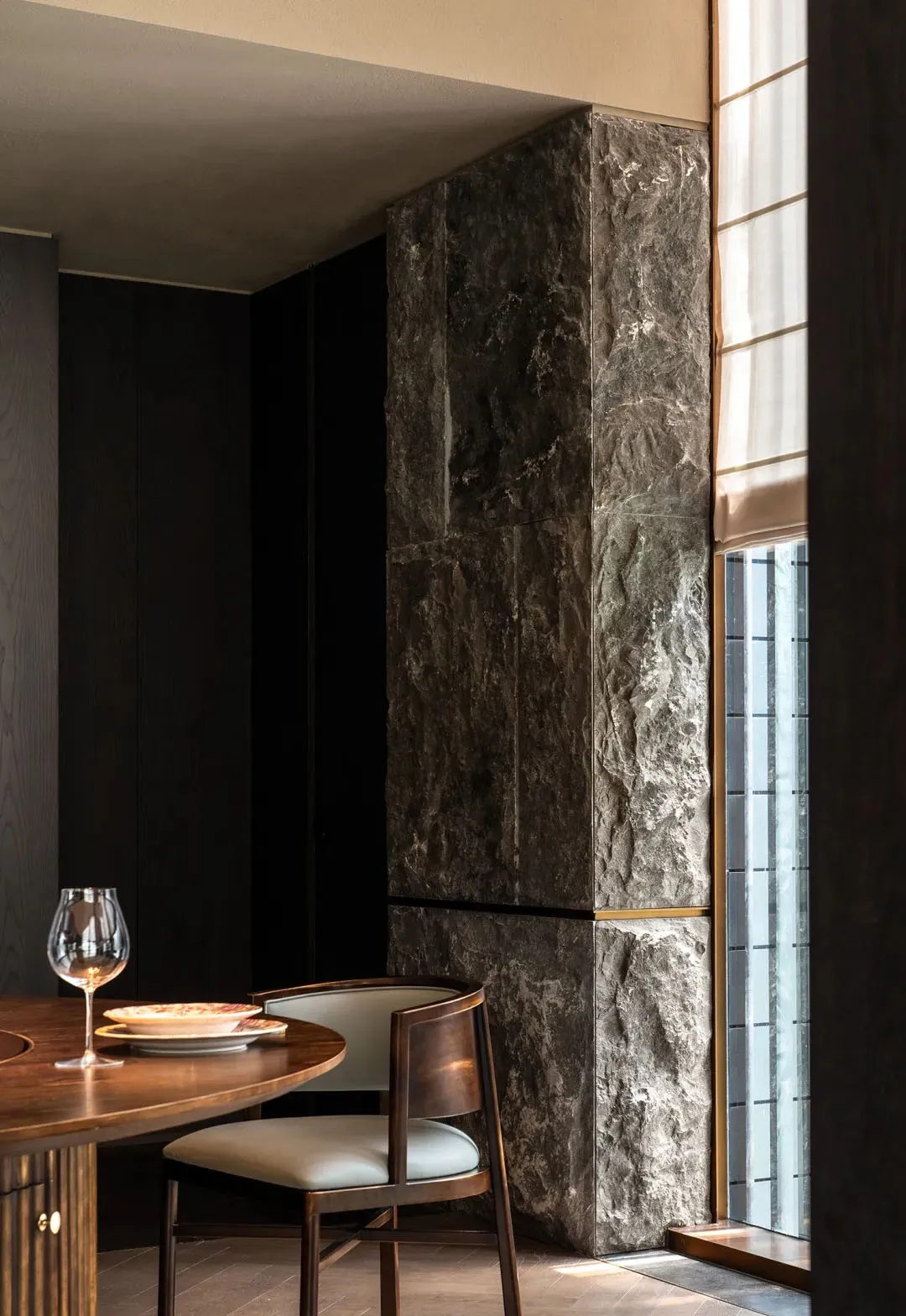 Modern dining area featuring a stone wall