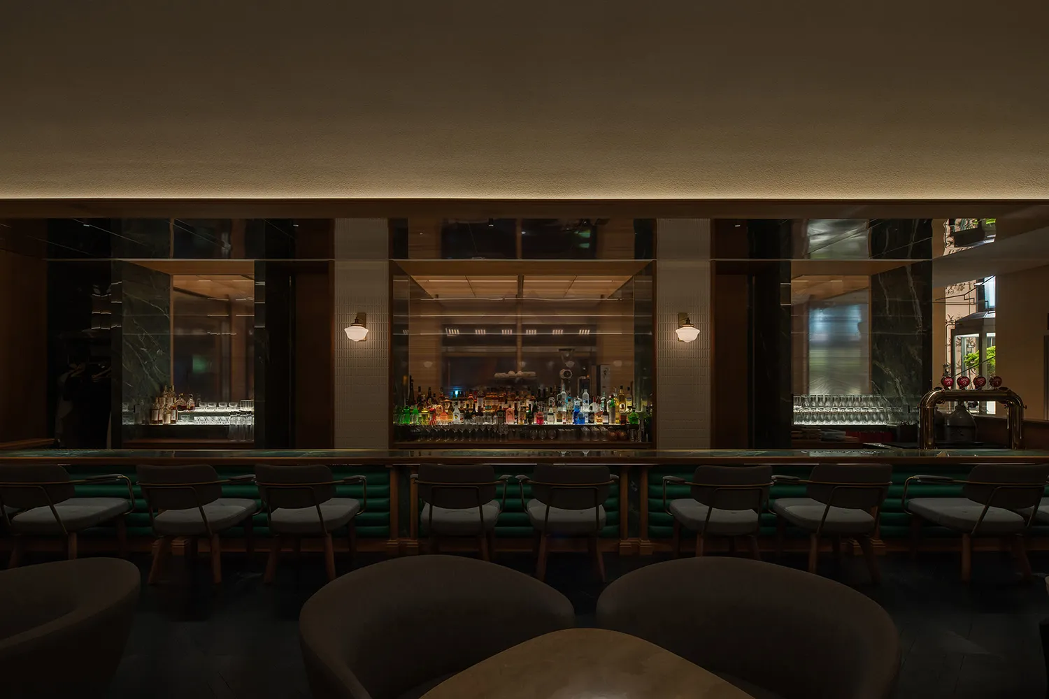 A modern bar interior featuring marble finishes and a sleek, contemporary design.