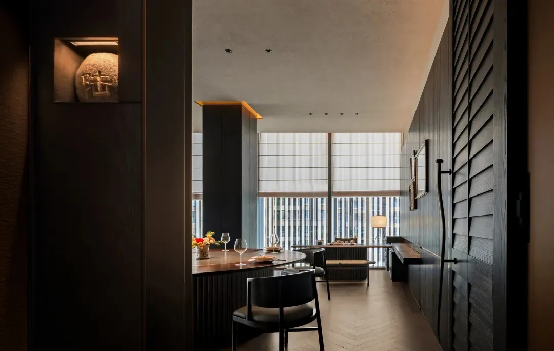 簡約風格的餐廳室內,搭配木質餐桌、玻璃窗與金屬點綴。