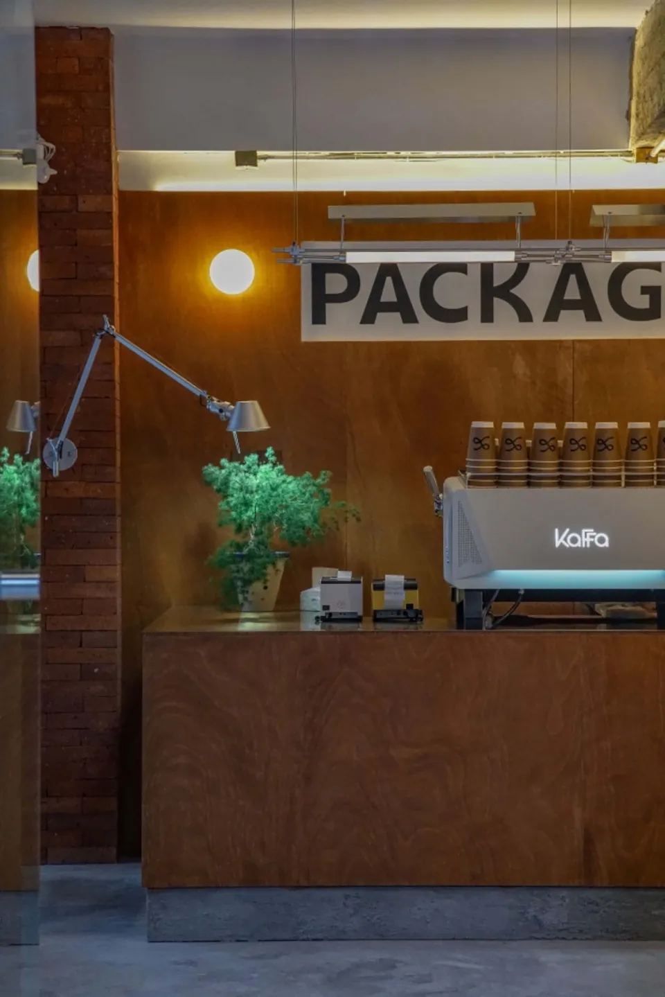 Interior of a modern coffee shop with a wooden counter and metal coffee machine.