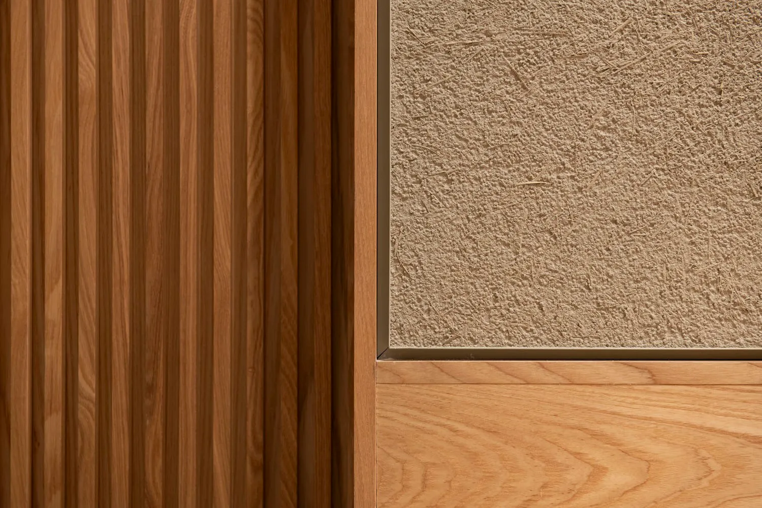 A minimalist interior with wooden panels and textured plaster walls.