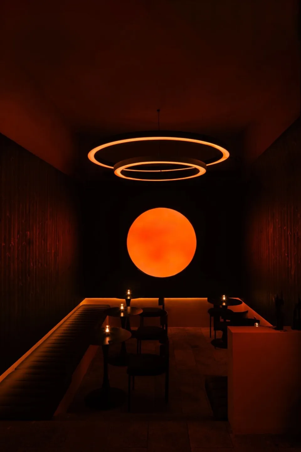 A modern restaurant bar with illuminated LED circle and dim ambient lighting