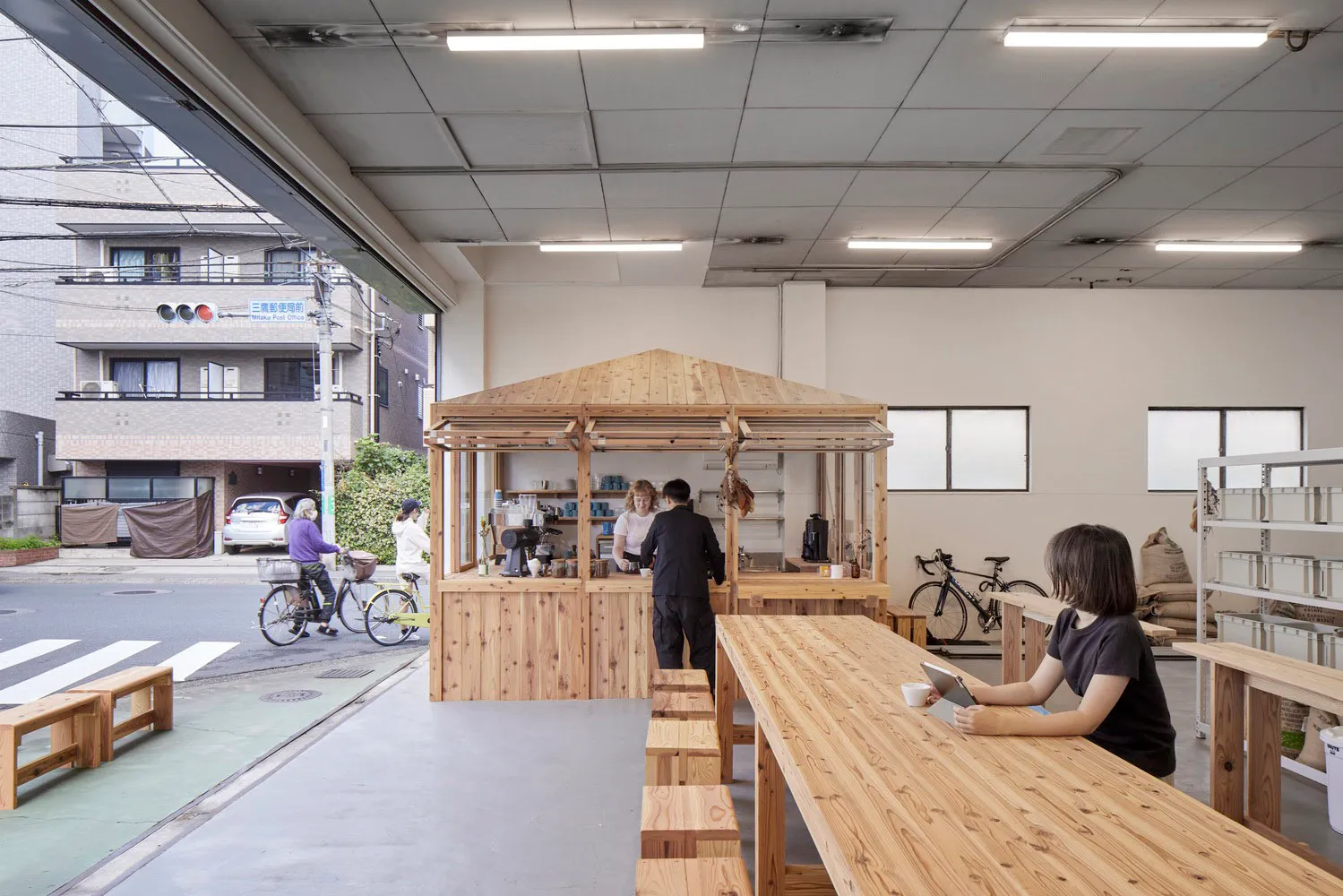 A modern industrial-style coffee shop with wooden features inside and a counter for ordering.