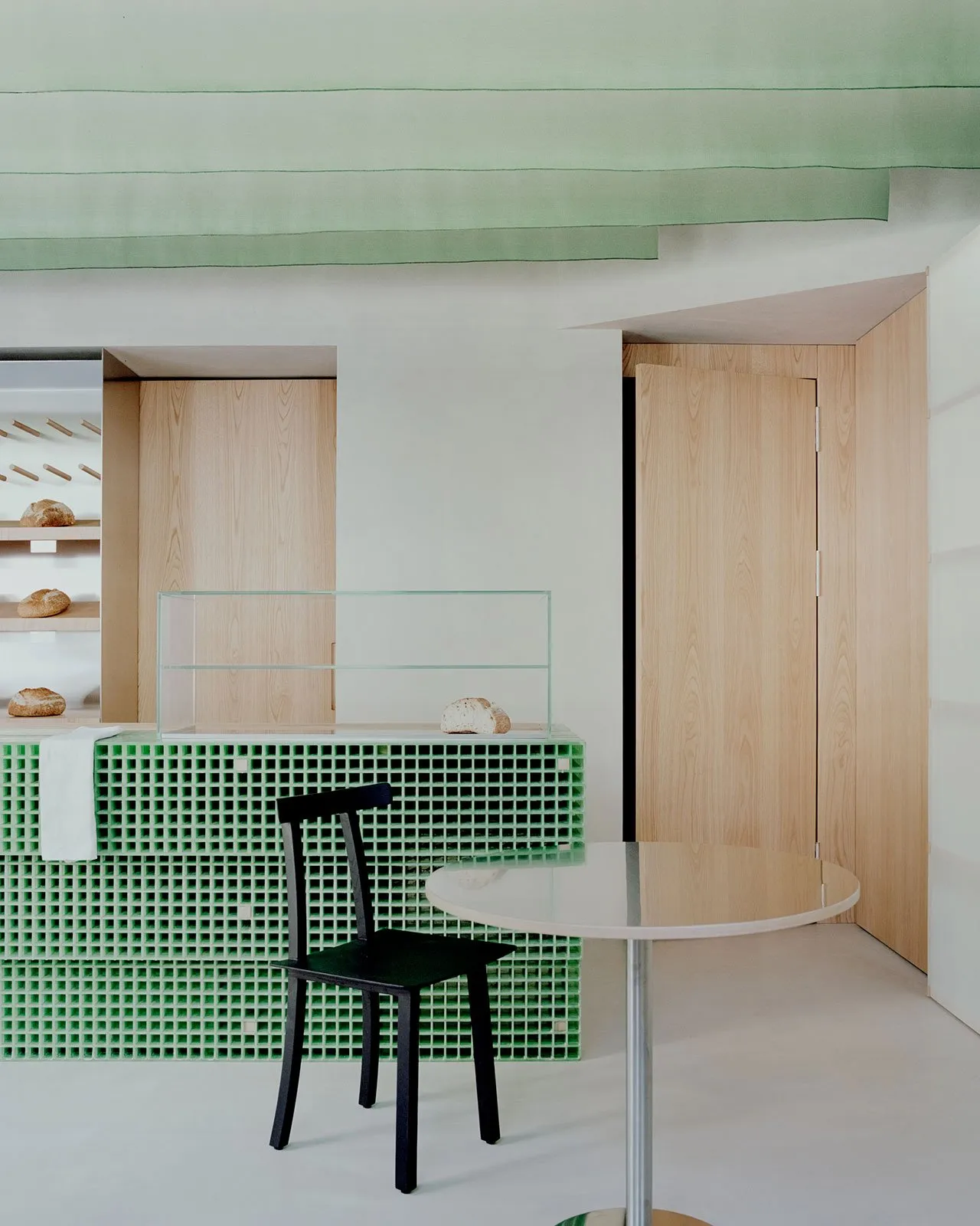 A modern interior featuring wooden furniture and green accents.