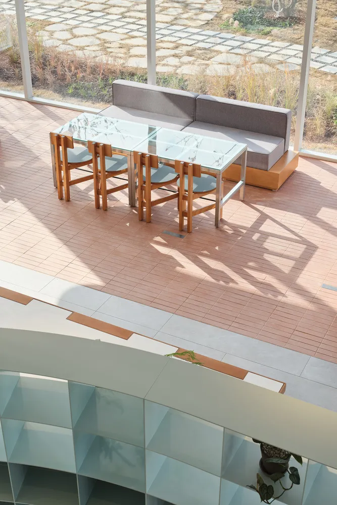 Modern lounge area featuring glass and wood furniture.