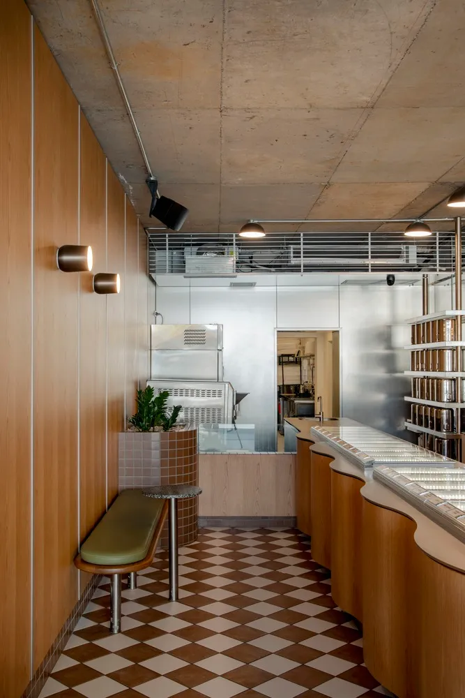 Modern minimalist restaurant interior with wood, concrete, and metal materials.