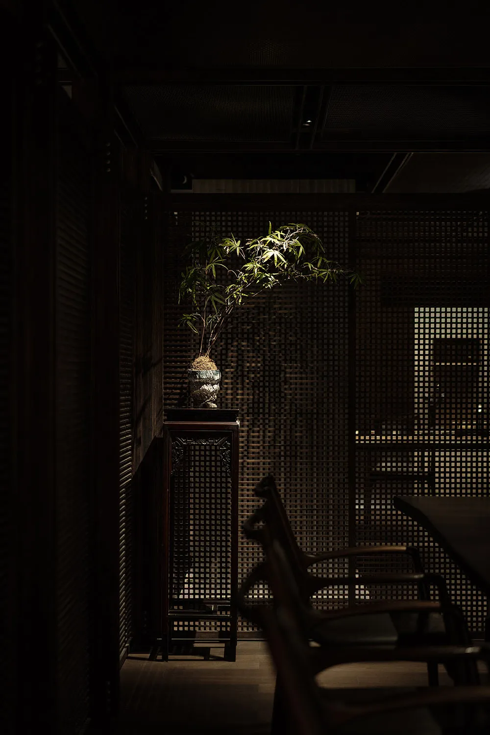 A traditional living room featuring wood-paneled walls, wooden furniture, and a potted plant.
